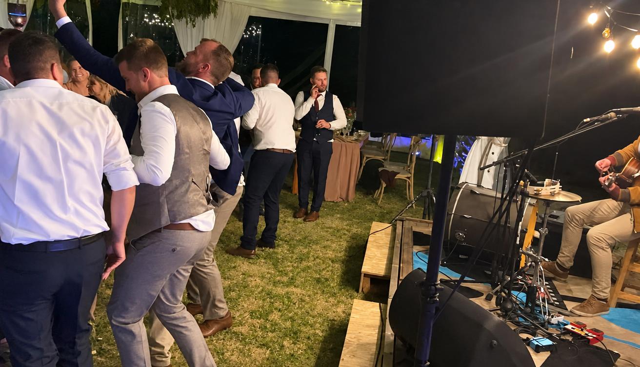 Wedding guests dancing next to the live band
